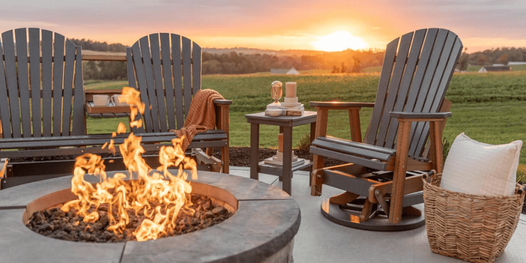 Outdoor chairs arranged around a fire pit with flames in the center