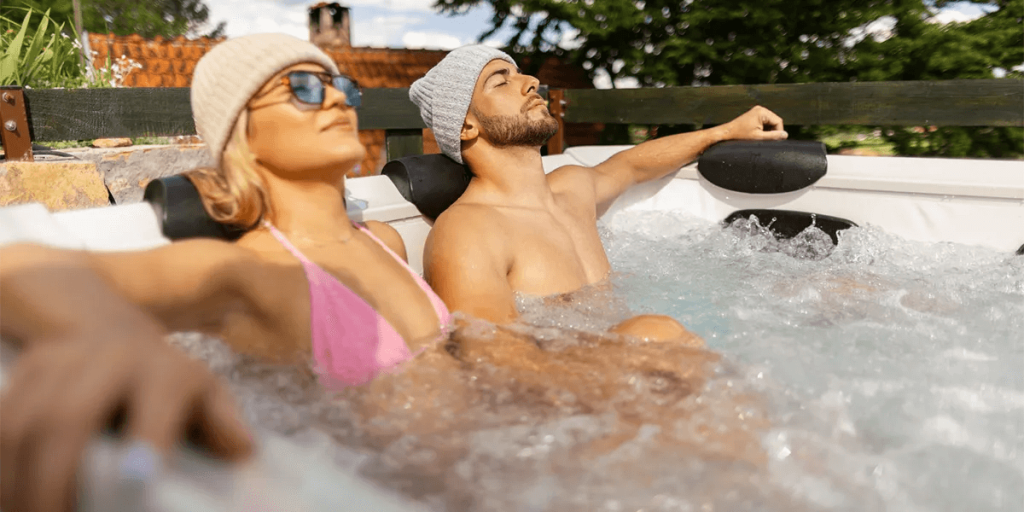 Couple relaxing in a hot tub after exercise, enjoying the benefits of hydrotherapy for muscle recovery and relaxation.